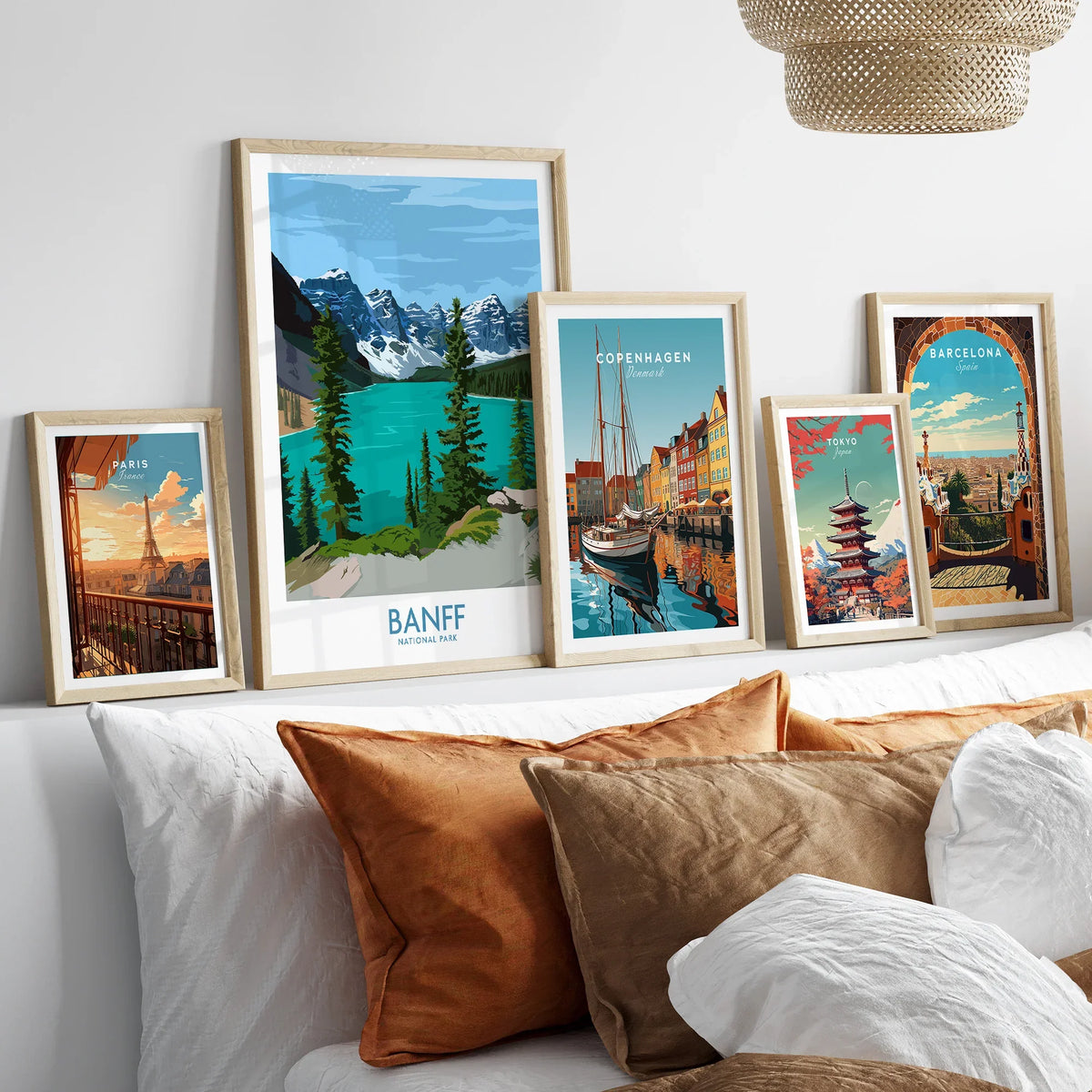 Framed travel posters above bed featuring Banff, Paris, Copenhagen, Tokyo, and Barcelona.
