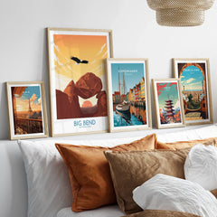 Five framed travel and city skyline art prints above bed with natural wood frames