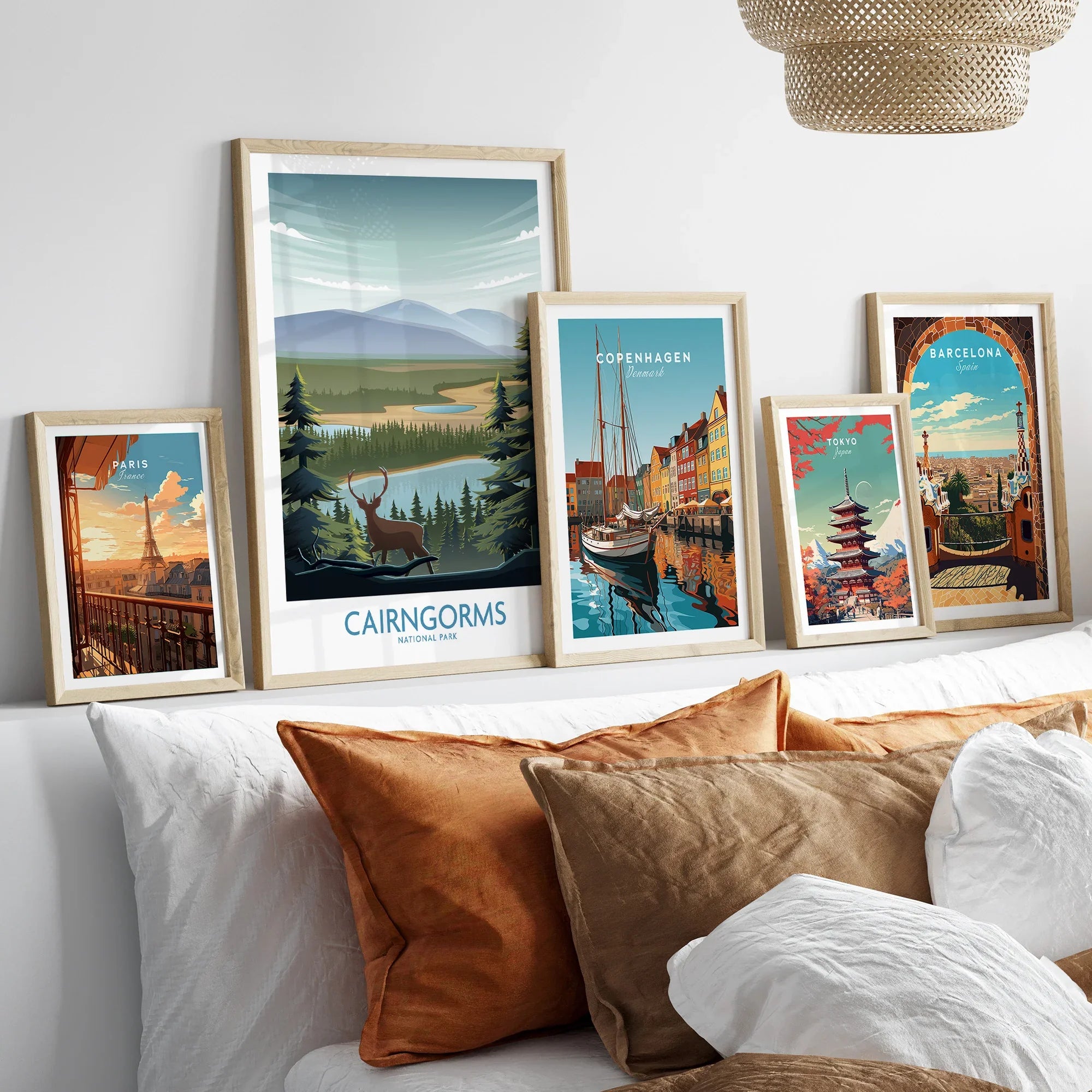 Set of five framed travel art prints above bed, featuring Paris, Cairngorms, Copenhagen, Tokyo, Barcelona.
