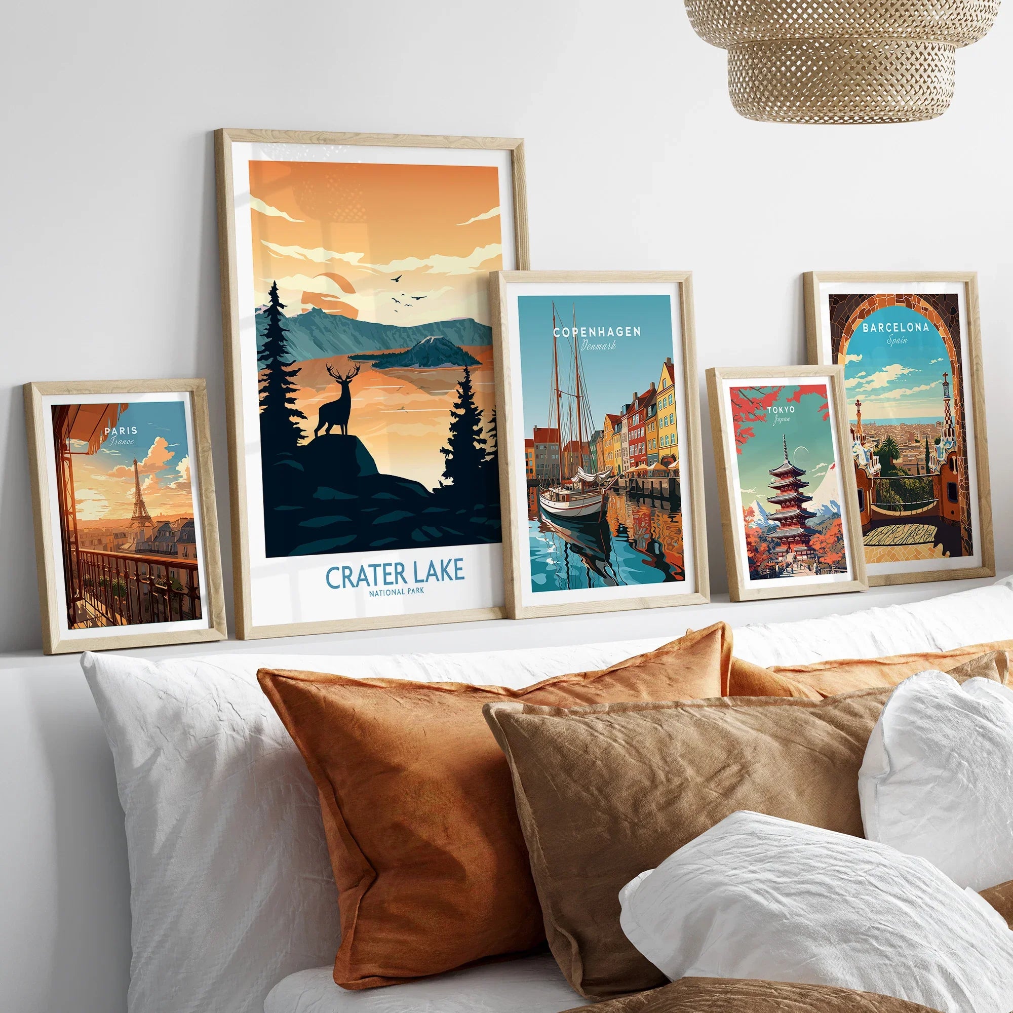 Set of five framed travel posters above bed, featuring Crater Lake, Paris, Copenhagen, Tokyo, Barcelona.