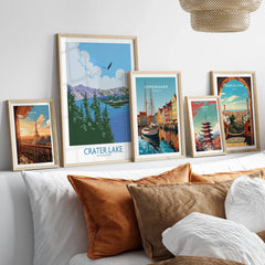 Set of five framed travel art prints above bed, featuring Paris, Crater Lake, Copenhagen, Tokyo, Barcelona.