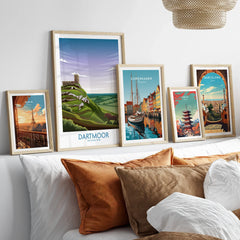 Set of five framed travel posters above bed, featuring Paris, Dartmoor National Park, Copenhagen, Tokyo, Barcelona.