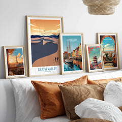 Framed art prints of Paris, Death Valley, Copenhagen, Tokyo, and Barcelona above bed