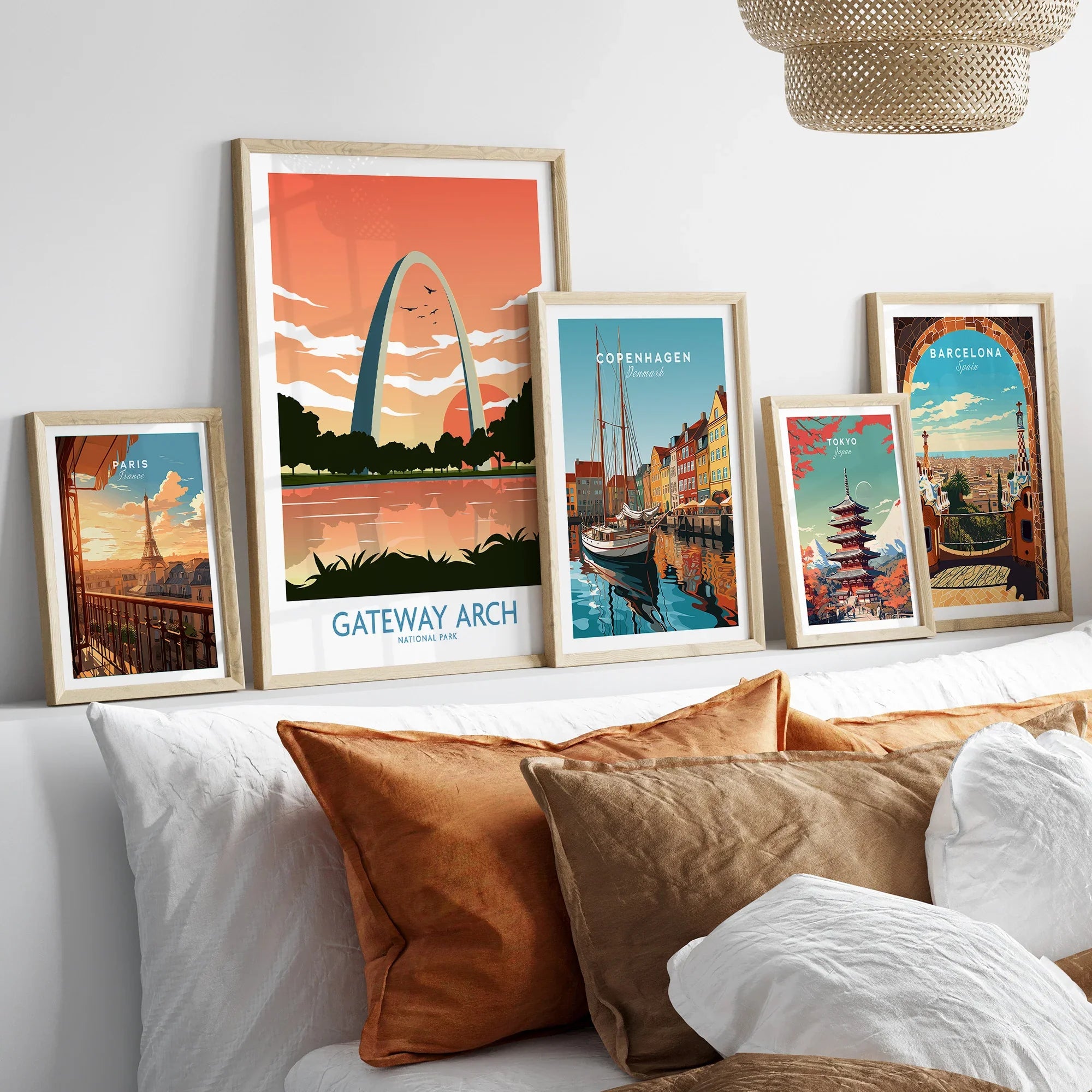 Framed travel posters and city skyline art prints displayed above a modern bed