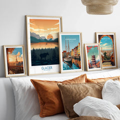 Five framed travel art prints above a bed, featuring Paris, Glacier National Park, Copenhagen, Tokyo, and Barcelona scenes.