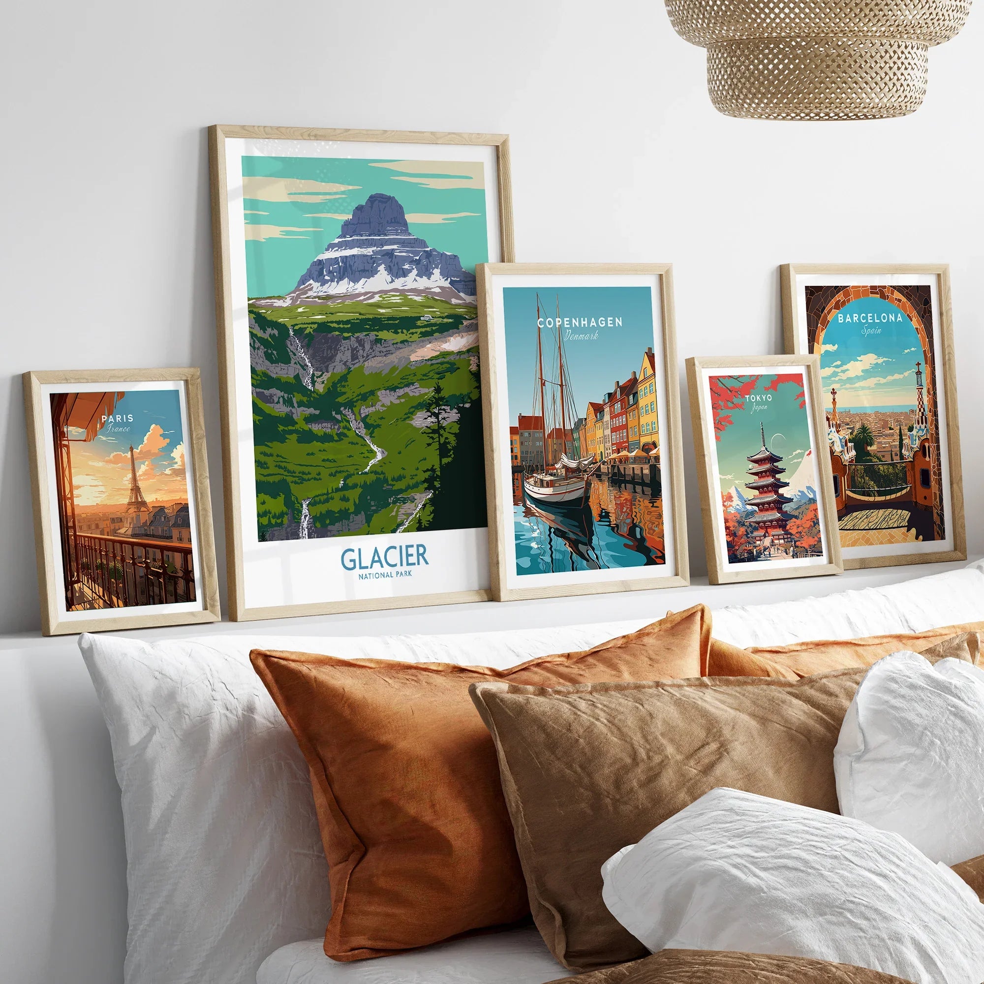 Framed travel art prints of Paris, Glacier National Park, Copenhagen, Tokyo, and Barcelona above bed
