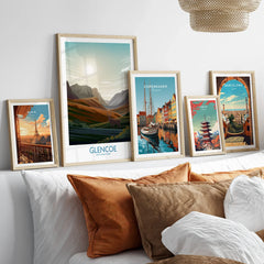 Framed travel posters of Paris, Glencoe, Copenhagen, Tokyo, and Barcelona above bed