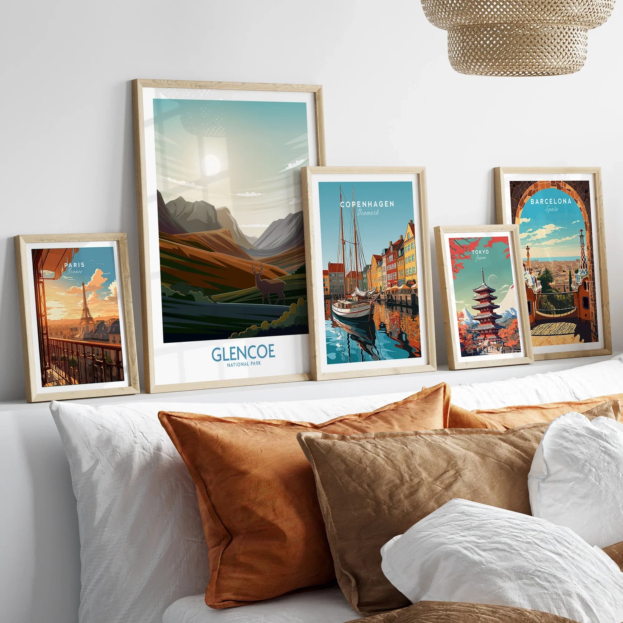 Framed travel posters of Paris, Glencoe, Copenhagen, Tokyo, and Barcelona above bed
