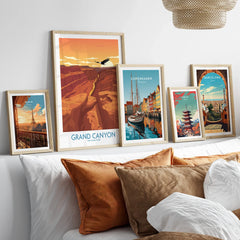 Framed travel posters of Grand Canyon, Paris, Copenhagen, Tokyo, and Barcelona above bed