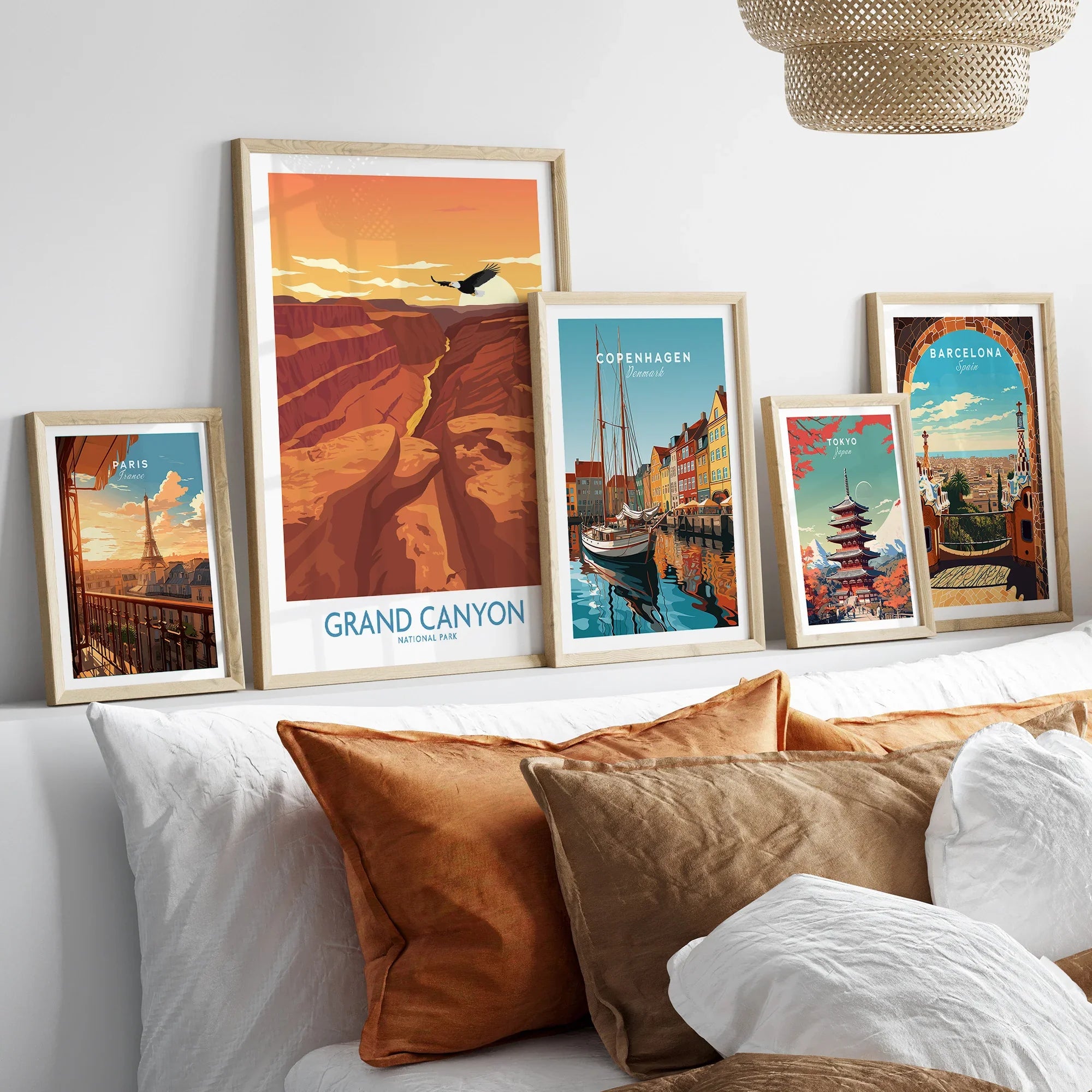 Framed travel posters of Grand Canyon, Paris, Copenhagen, Tokyo, and Barcelona above bed