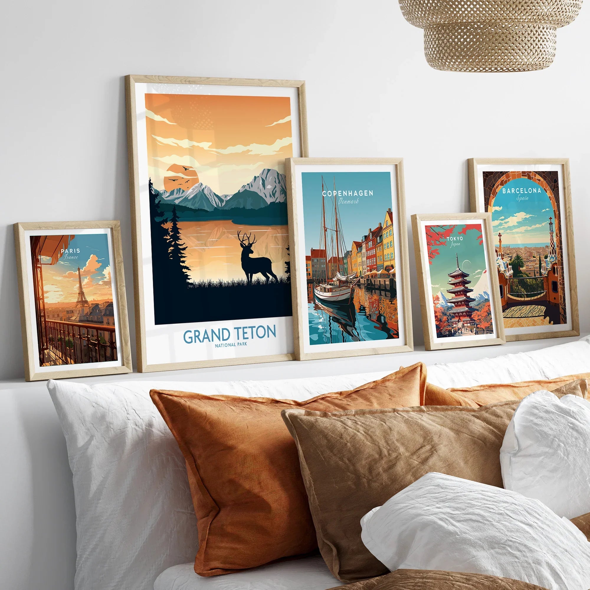 Framed travel posters of Grand Teton, Paris, Copenhagen, Tokyo, and Barcelona above bed