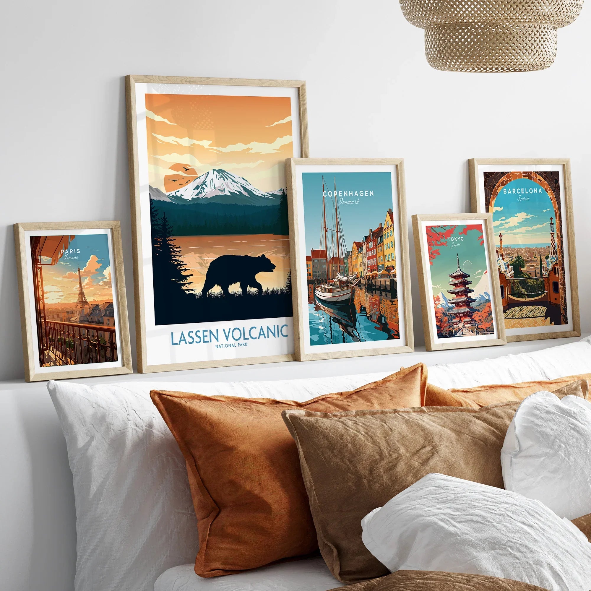 Set of five framed travel and city wall art prints above bed with natural wood frames