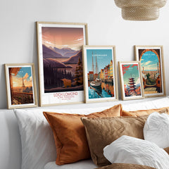 Framed travel art prints of Paris, Loch Lomond, Copenhagen, Tokyo, and Barcelona above bed