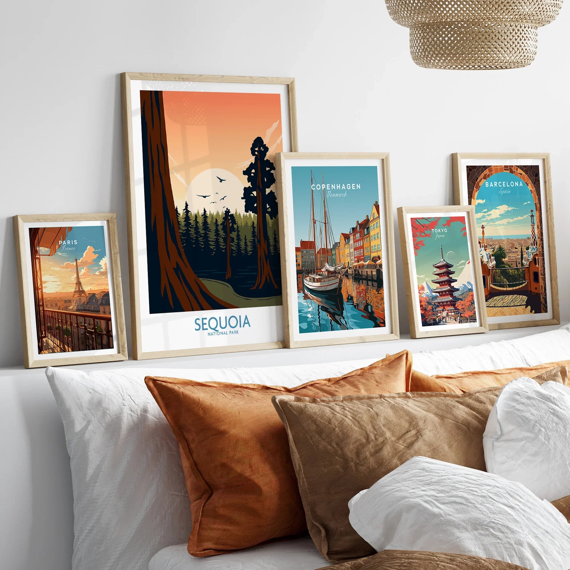 Set of five framed travel and city wall art prints above a bed with neutral pillows