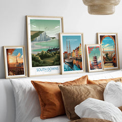 Set of five framed travel art prints above bed, featuring Paris, South Downs, Copenhagen, Tokyo, Barcelona.