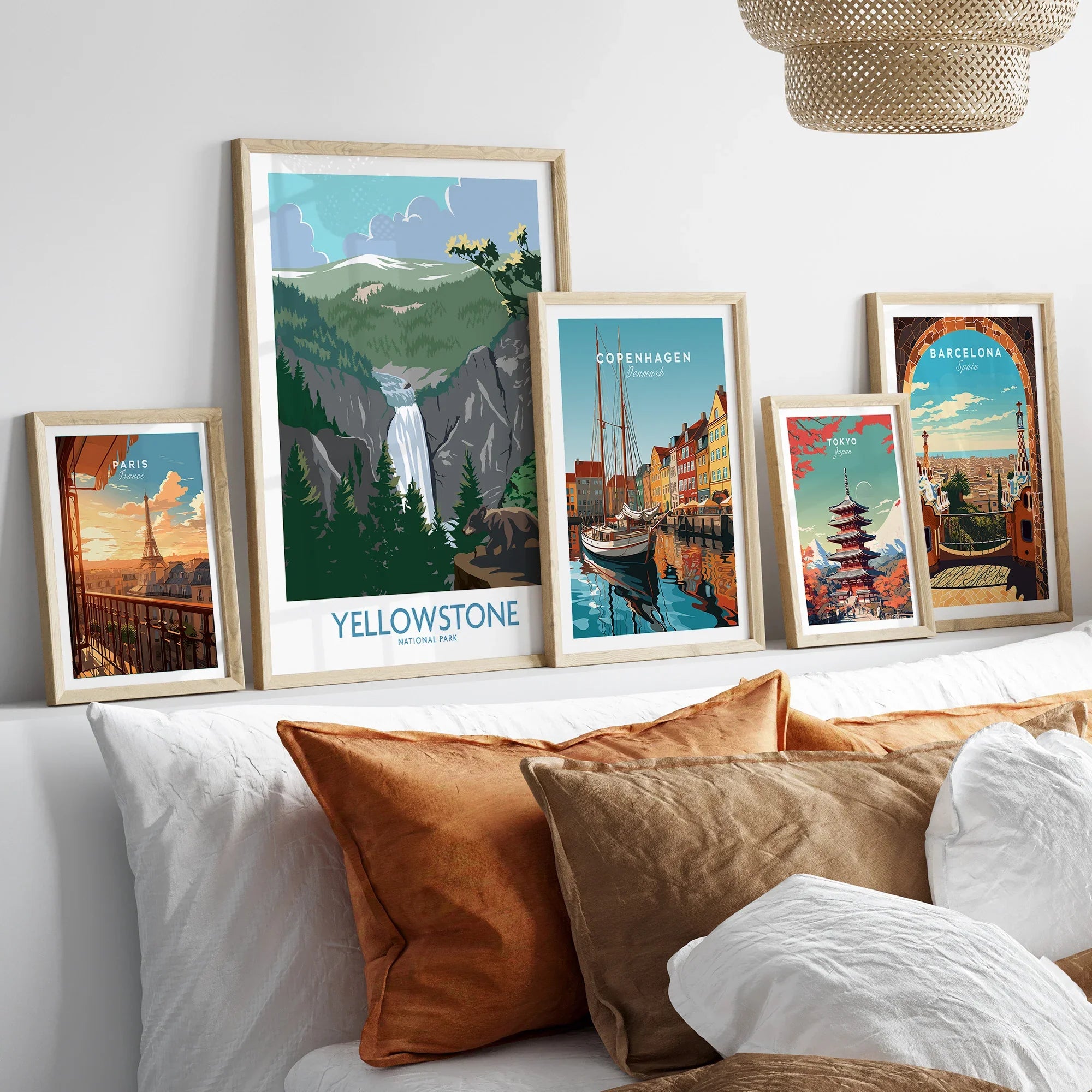 Set of five framed travel art prints above bed featuring Yellowstone, Paris, Copenhagen, Tokyo, Barcelona.