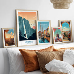 Set of five framed travel posters above bed, featuring Yosemite, Paris, Copenhagen, Tokyo, Barcelona.