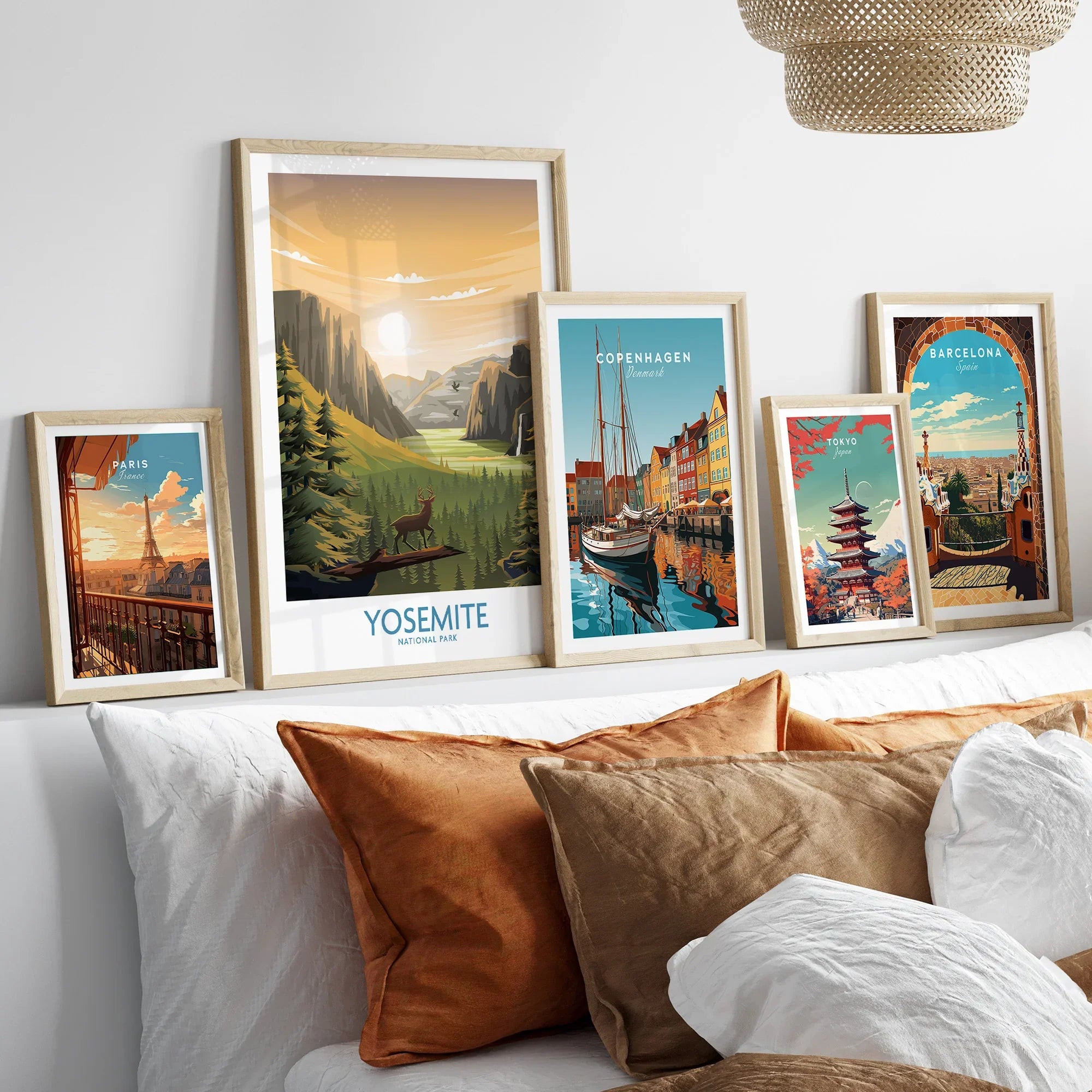 Framed travel posters of Yosemite, Paris, Copenhagen, Tokyo, and Barcelona above a bed