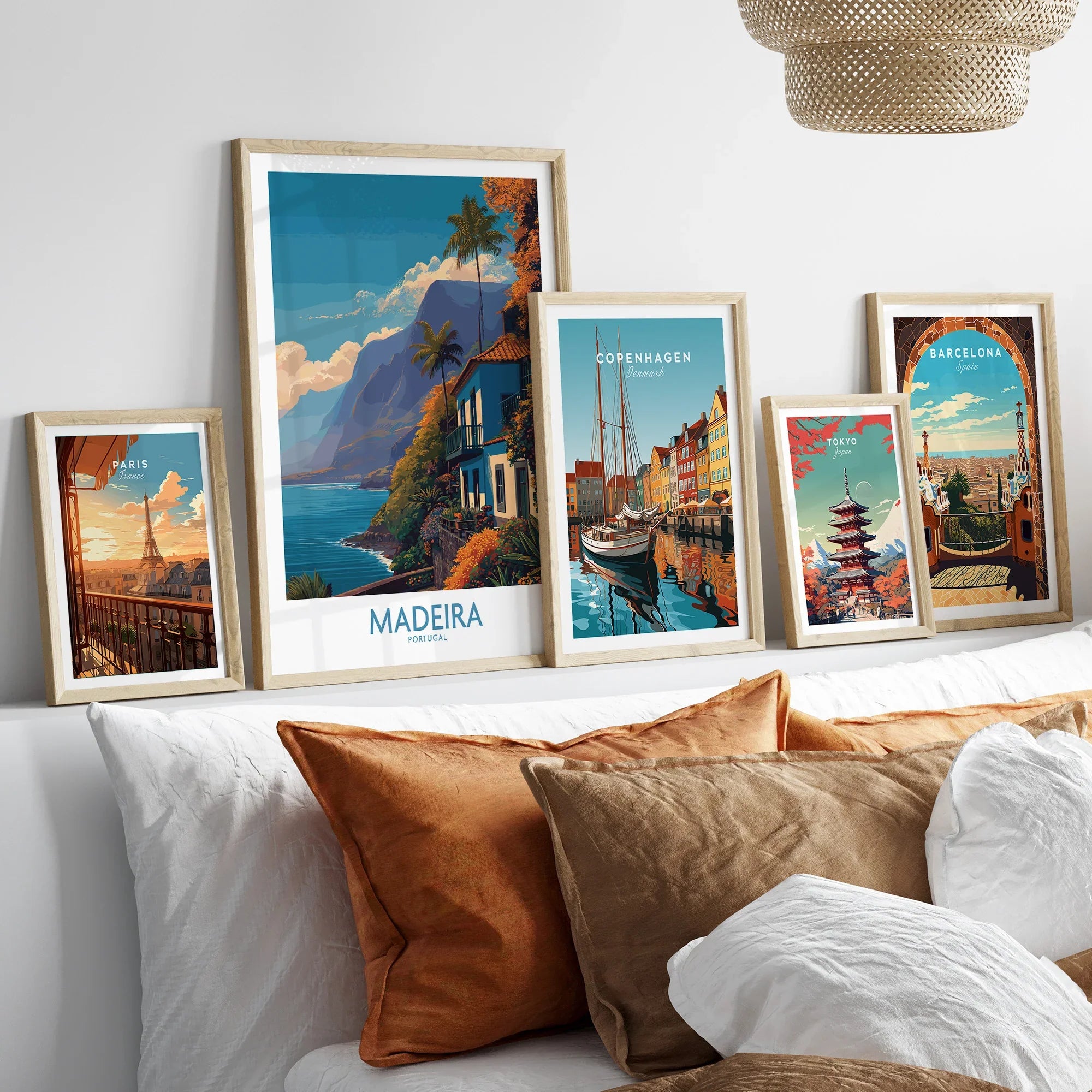 Framed travel posters of Paris, Madeira, Copenhagen, Tokyo, and Barcelona above a bed