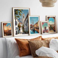 Mijas Spain Travel Poster | Traditional White Street Wall Art Print displayed among other travel posters on a stylish sofa.
