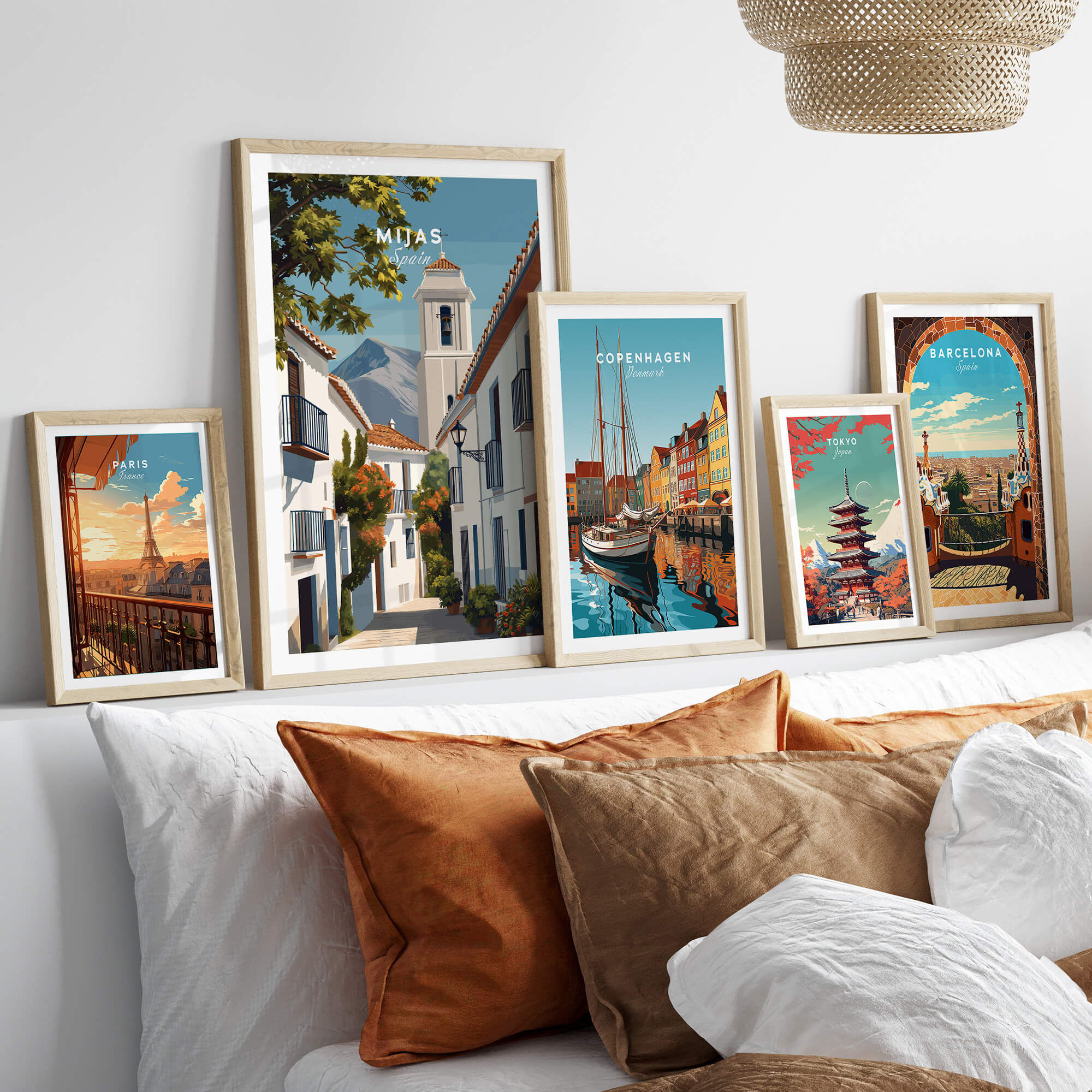 Mijas Spain Travel Poster | Traditional White Street Wall Art Print displayed among other travel posters on a stylish sofa.