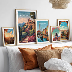 Montepulciano Italy Travel Poster | Tuscan Sunset Wall Art Print displayed among other travel posters on a stylish sofa.