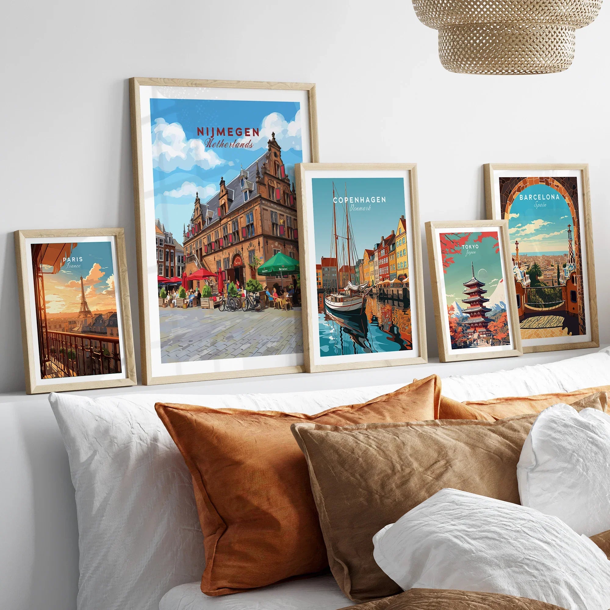 Framed travel posters of Nijmegen, Copenhagen, Paris, Tokyo, and Barcelona above a bed