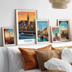 Framed travel posters featuring city skylines above a bed with natural wood frames.