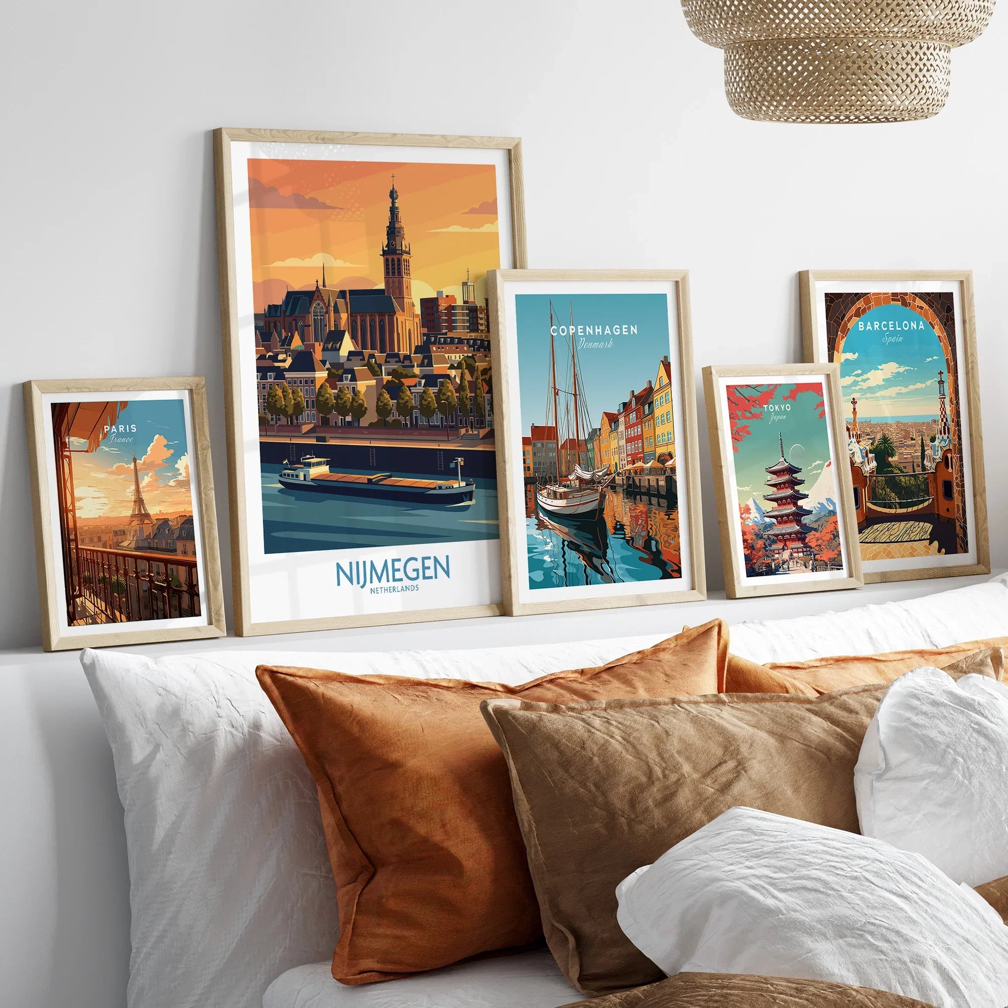 Framed travel posters featuring city skylines above a bed with natural wood frames.