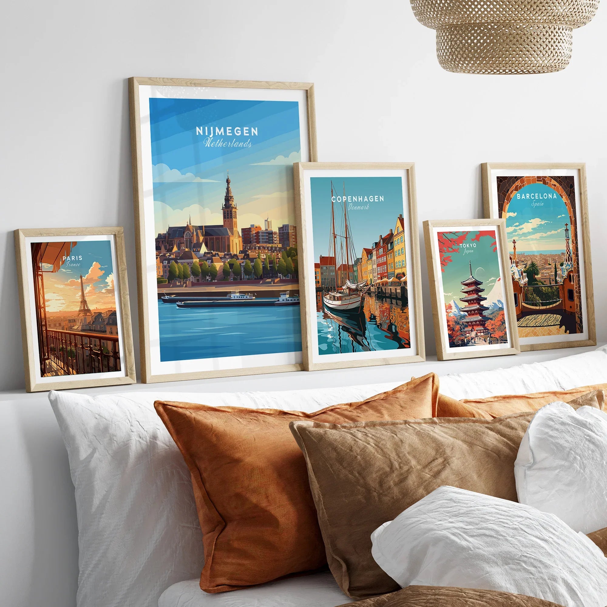 Framed travel posters of Paris, Nijmegen, Copenhagen, Tokyo, and Barcelona above a bed