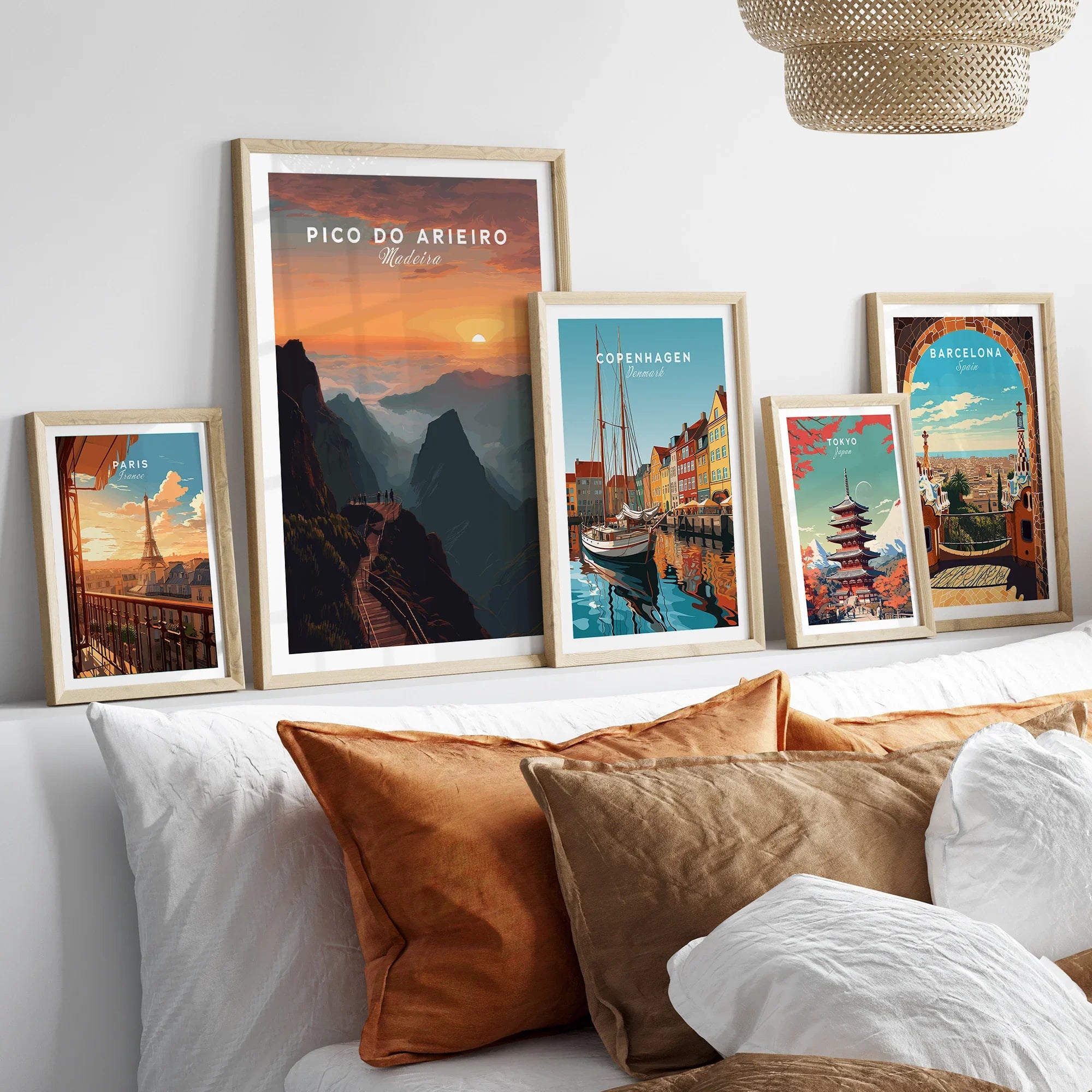 Framed travel posters of Paris, Madeira, Copenhagen, Tokyo, and Barcelona above a bed.