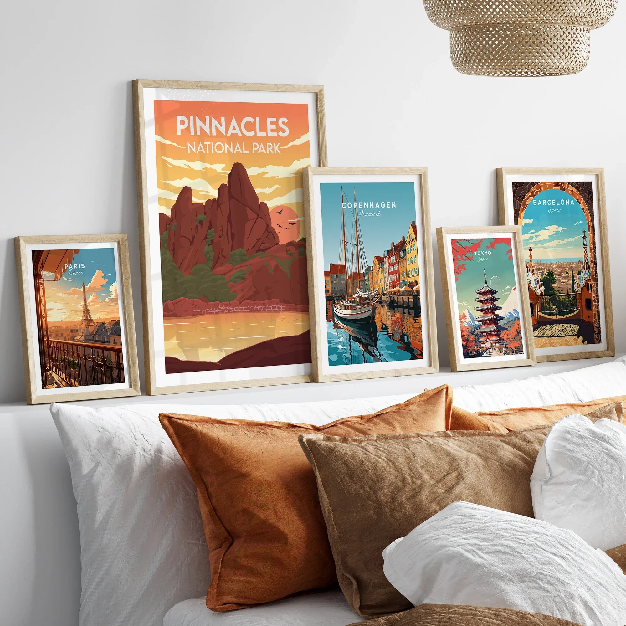 Framed travel posters of Pinnacles National Park, Paris, Copenhagen, Tokyo, and Barcelona above bed