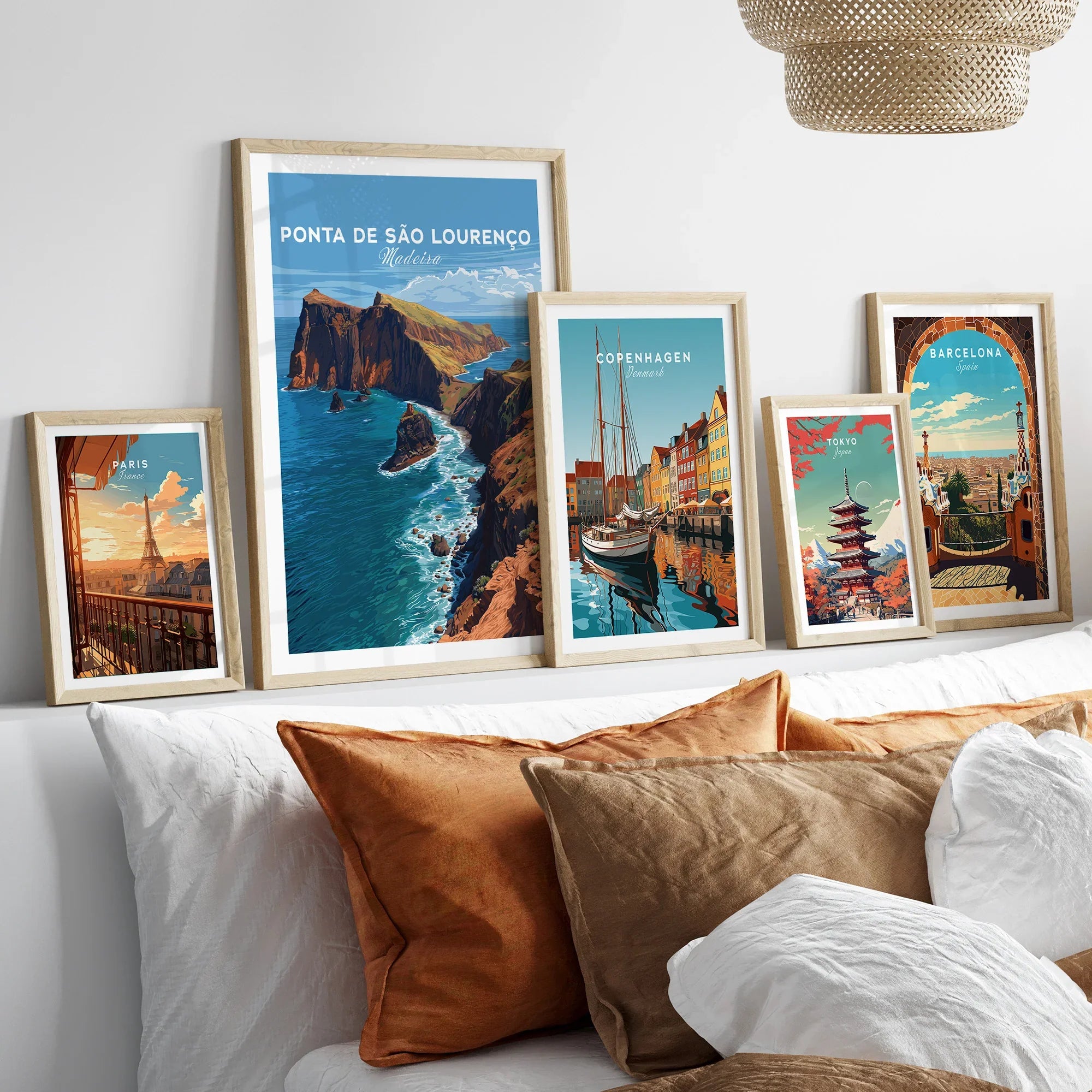 Framed travel posters set above bed, featuring Paris, Madeira, Copenhagen, Tokyo, Barcelona.