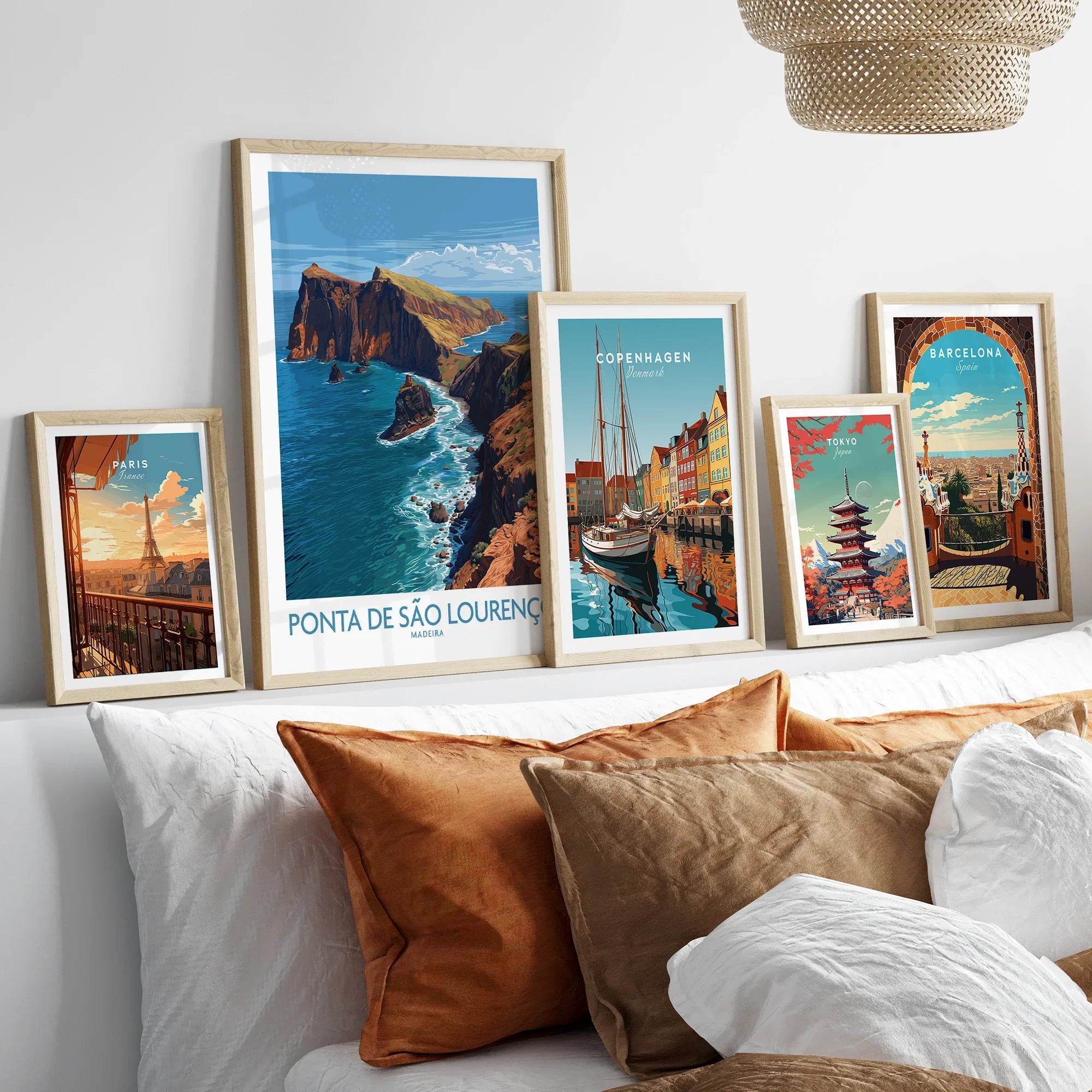 Five framed travel art prints above bed, featuring city skylines and landscapes.
