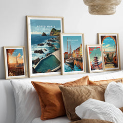 Set of five framed travel posters above bed featuring Paris, Porto Moniz, Copenhagen, Tokyo, Barcelona.