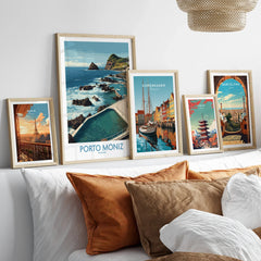 Framed travel art prints of Paris, Porto Moniz, Copenhagen, Tokyo, and Barcelona above bed