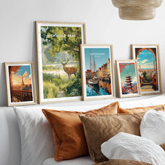 Framed travel art prints of Paris, Richmond Park, Copenhagen, Tokyo, and Barcelona above bed.