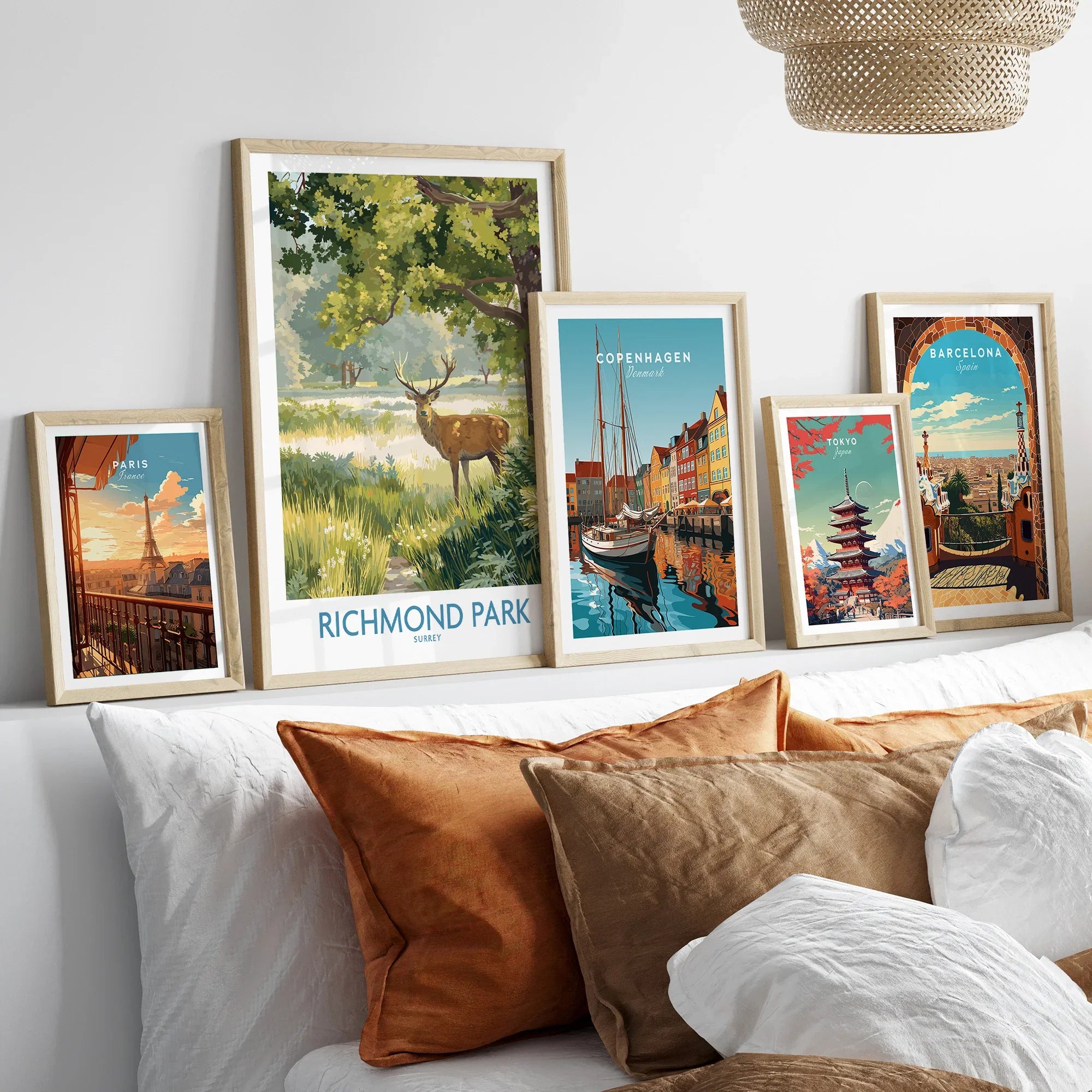 Framed travel and national park art prints above bed, featuring Paris, Richmond Park, Copenhagen, Tokyo, and Barcelona.