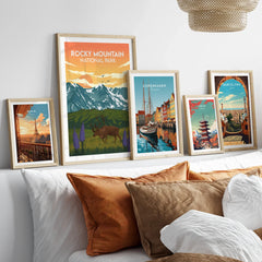 Set of five framed travel art prints featuring national park and city landmarks above bed