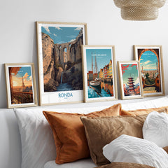 Ronda Spain Poster | Dramatic Andalusian Mountain Bridge Canvas Print displayed among other city posters on a cozy couch.