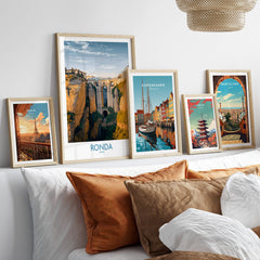 Ronda Spain Poster | Iconic Stone Bridge & Valley View Canvas Print displayed among other city posters on a soft couch.