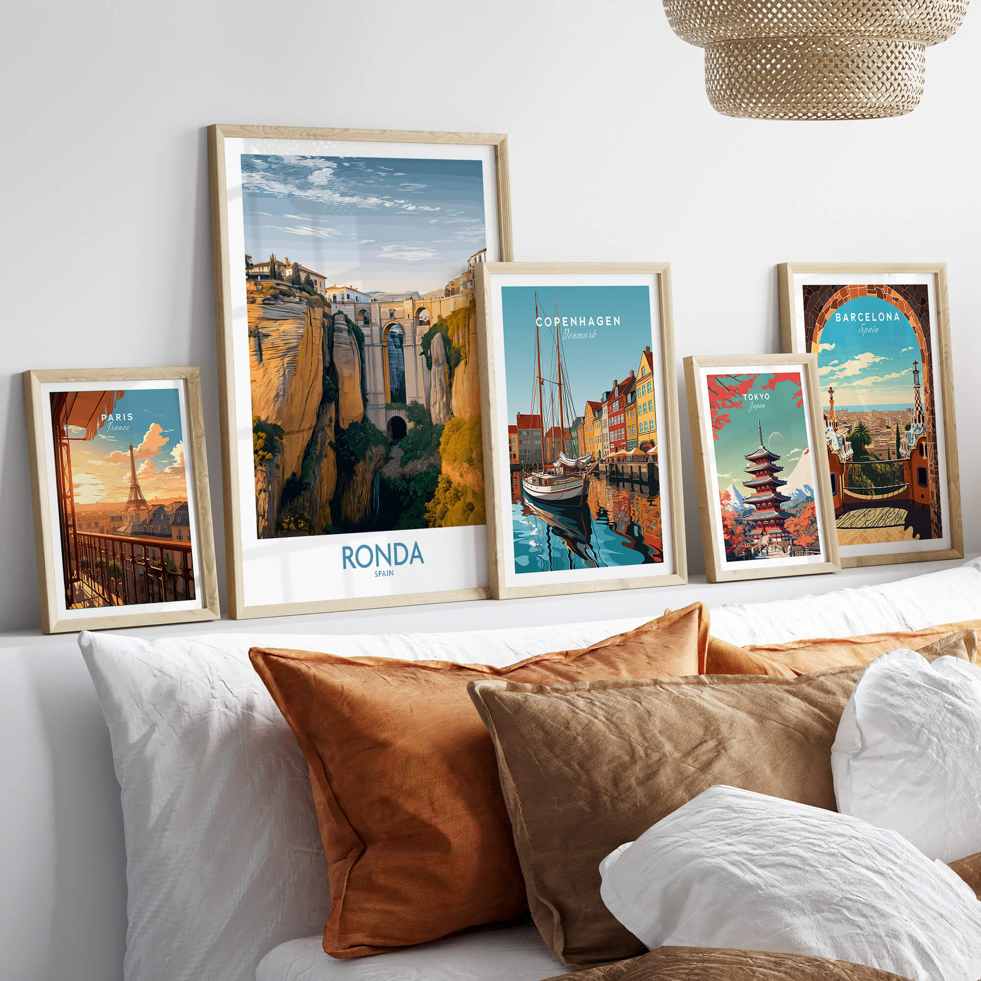 Ronda Spain Poster | Iconic Stone Bridge & Valley View Canvas Print displayed among other city posters on a soft couch.
