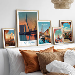 Set of five framed city travel posters above bed with natural wood frames, modern wall art