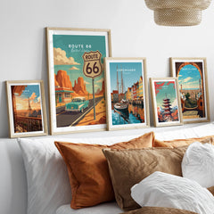 Framed travel posters of Route 66, Paris, Copenhagen, Tokyo, and Barcelona above a bed
