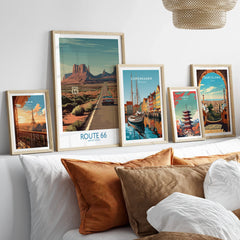 Framed travel art prints of Route 66, Paris, Copenhagen, Tokyo, and Barcelona above bed