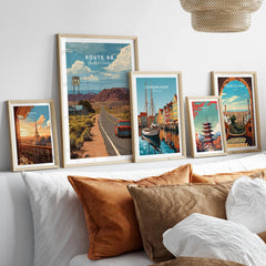 Set of five framed travel posters above bed, featuring Route 66, Paris, Copenhagen, Tokyo, Barcelona
