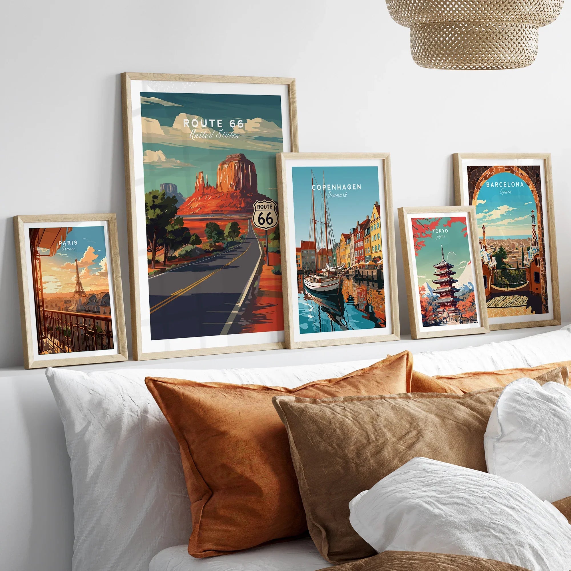 Framed travel posters featuring Route 66, Paris, Copenhagen, Tokyo, Barcelona above a bed.