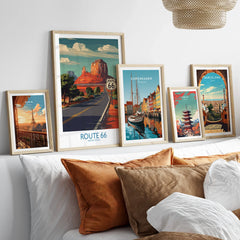 Framed travel art prints of Route 66, Paris, Copenhagen, Tokyo, and Barcelona above bed