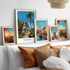Five framed travel art prints with natural wood frames displayed above a bed
