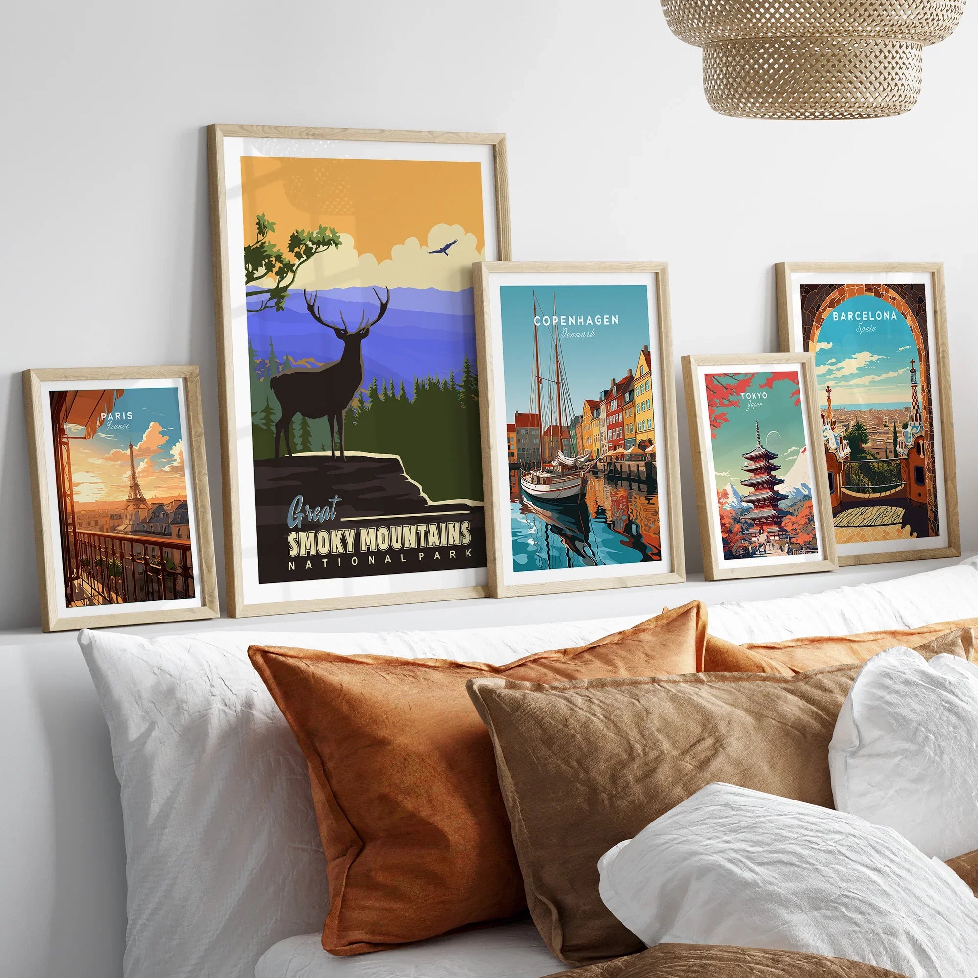 Set of five framed travel art prints above bed, featuring Paris, Smoky Mountains, Copenhagen, Tokyo, Barcelona.